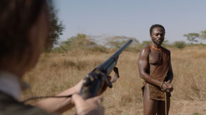 A woman pointing a gun toward a black man